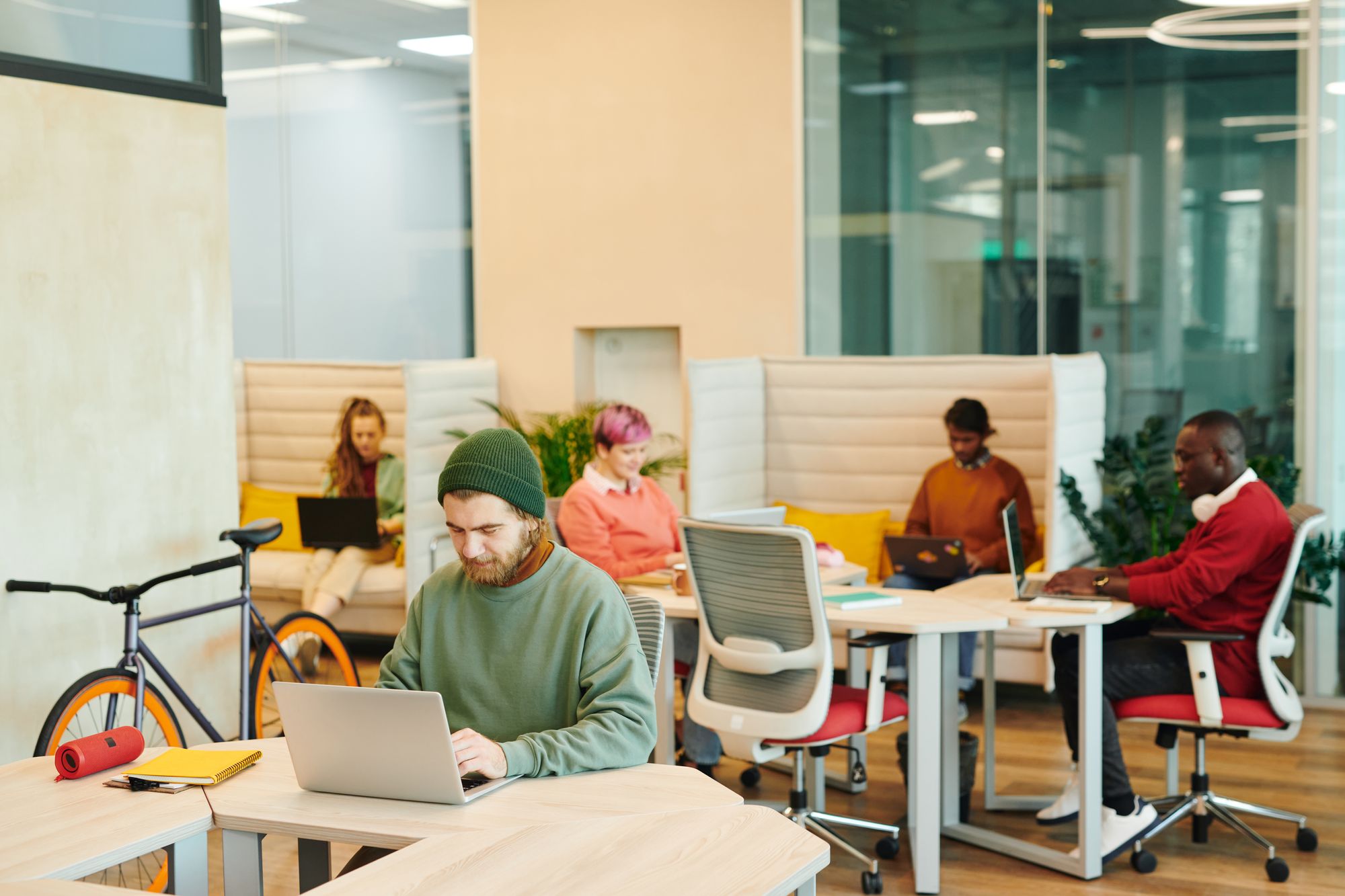 Students working quietly on laptops in a modern shared space